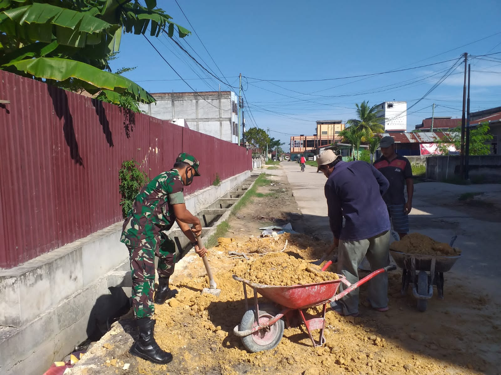 Sertu Sugianto Bantu Masyarakat Menimbun Jalan